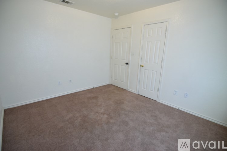 A room with two doors and carpeted floor.