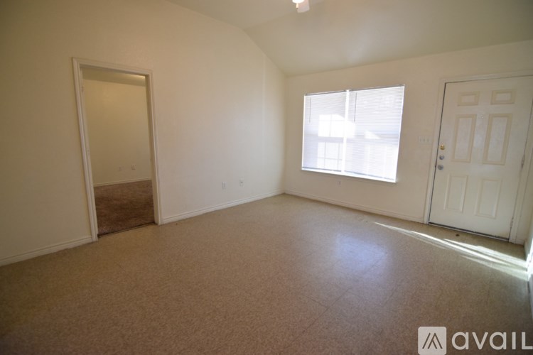 A room with a carpeted floor and two doors, one of which is open.