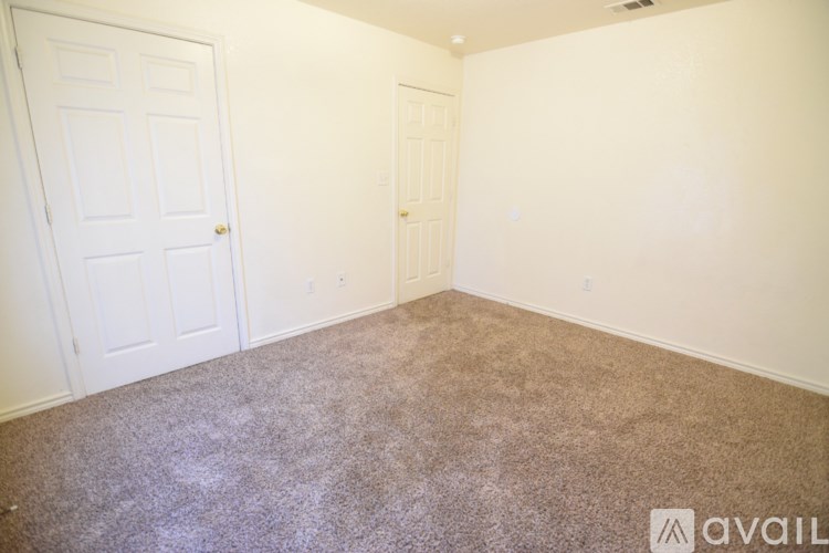 A room with two doors and carpeted floor.