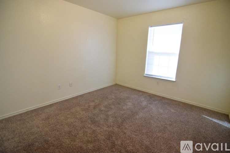 A room with a carpeted floor and a window.