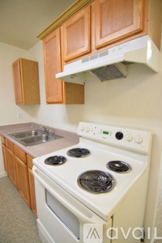 A white stove top oven with four burners and a white microwave above it.