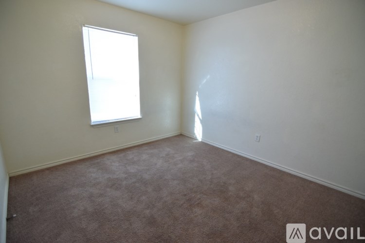 A room with a window and carpeted floor.