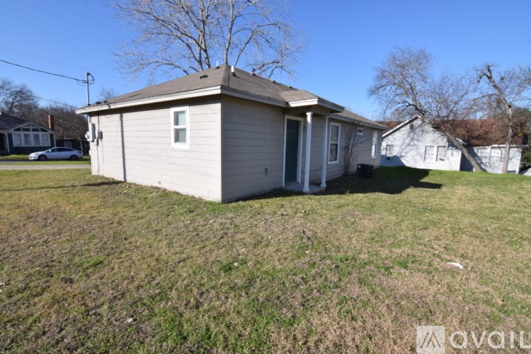 A small house with a car parked in the driveway.