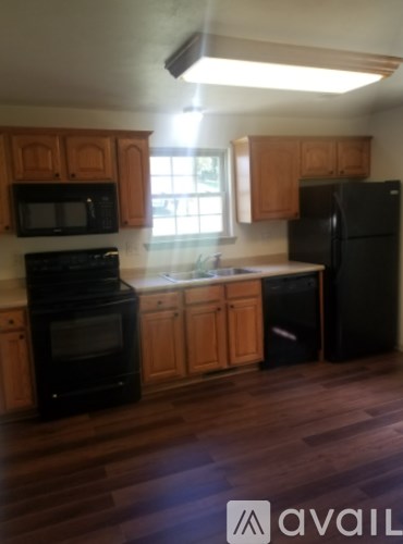 A kitchen with wooden cabinets and black appliances.