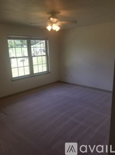 A room with a ceiling fan and a window.
