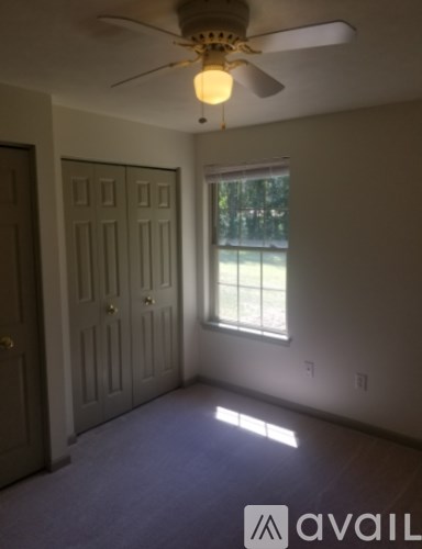 A room with a ceiling fan and a window.