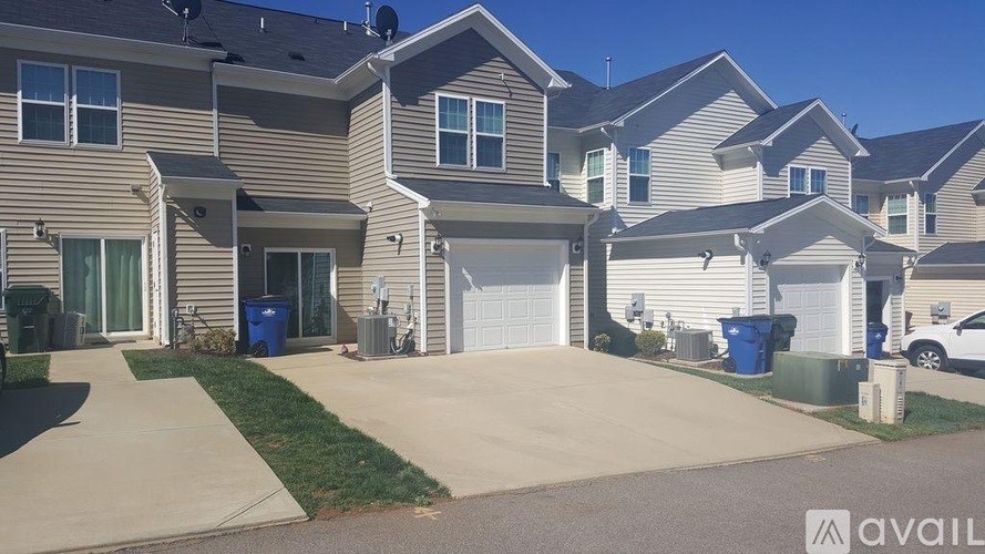 A row of houses with a blue trash bin in front of the first house.