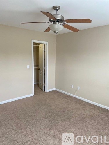 A room with a ceiling fan and a carpeted floor.