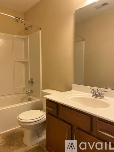 A bathroom with a toilet, sink, and bathtub.