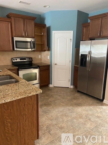 A kitchen with brown cabinets and a white door.