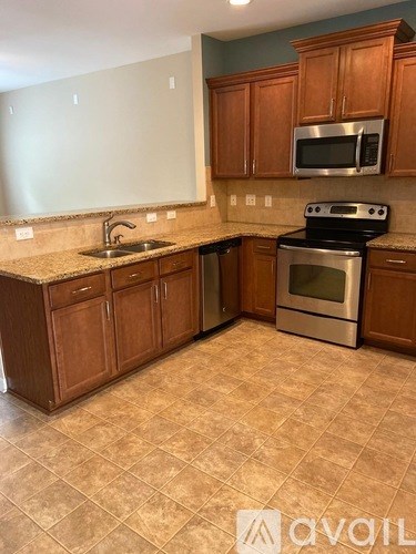 A kitchen with wooden cabinets and a tiled floor.