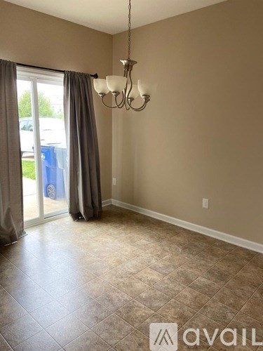 A room with a chandelier and a sliding glass door.
