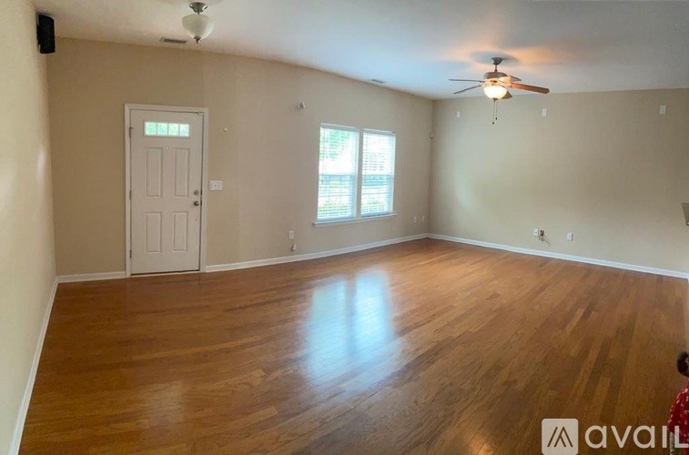 A room with wooden flooring and a ceiling fan.
