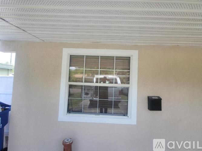 A window with a view of a street and a car.