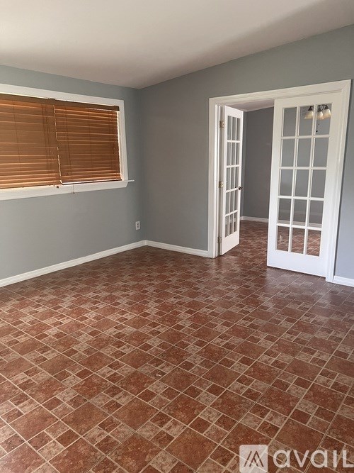A room with a tiled floor and a doorway leading to another room.