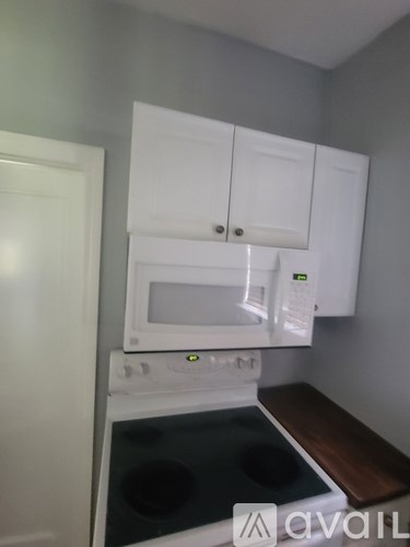 A white oven and microwave are installed in a kitchen.