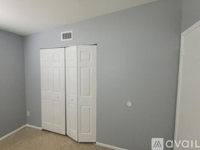 A room with two white doors and a carpeted floor.