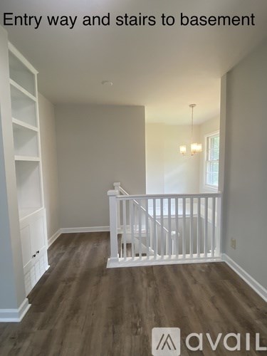 A room with a staircase leading to a basement.