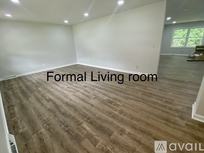 A formal living room with wooden flooring and white walls.