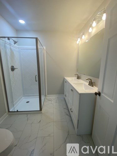 A bathroom with a toilet, sink, and shower.