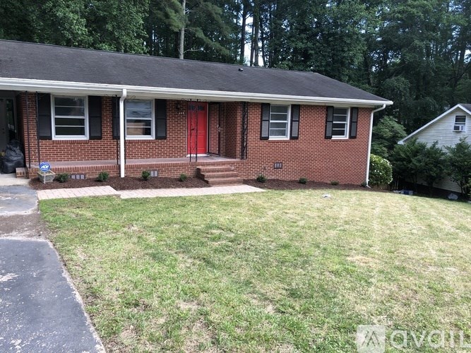 A red brick house with a red door and a small porch.