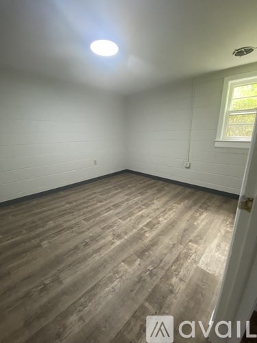 A room with wooden flooring and a window.