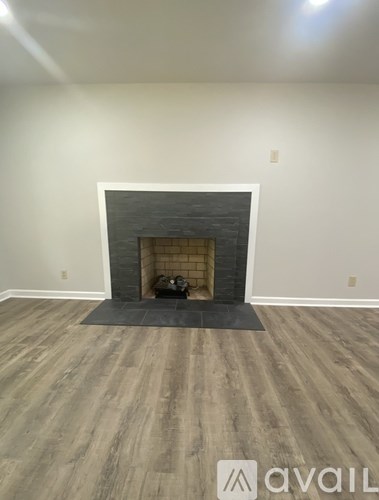 A room with a fireplace and wooden flooring.