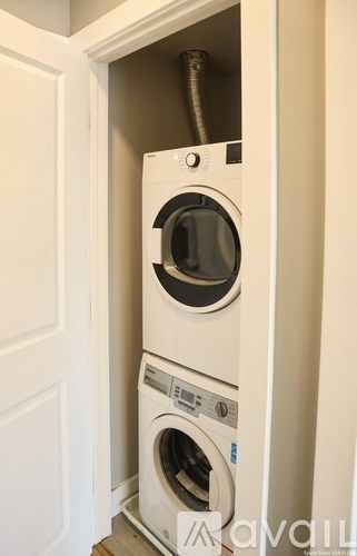 A white washing machine and dryer in a cabinet.