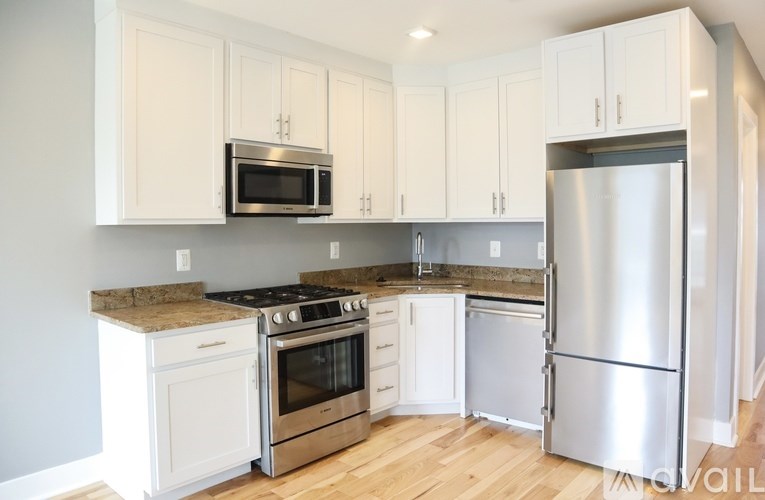 A kitchen with white cabinets and stainless steel appliances.