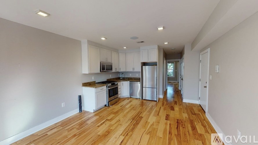 A kitchen with wooden floors and stainless steel appliances.