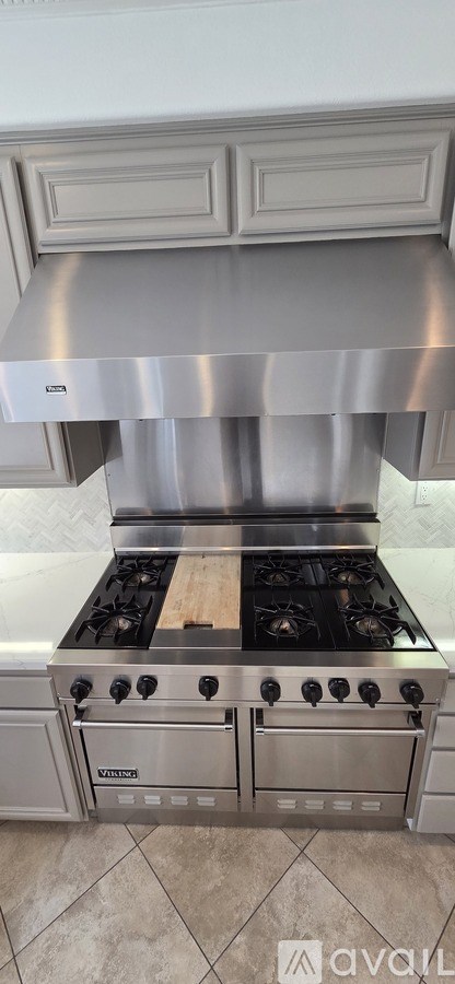 A stainless steel range hood above a stove.
