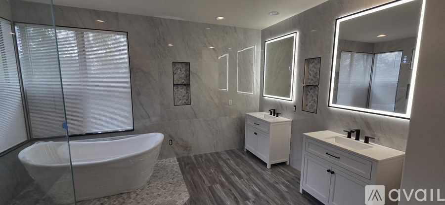 A bathroom with a tub, sink, and mirror.