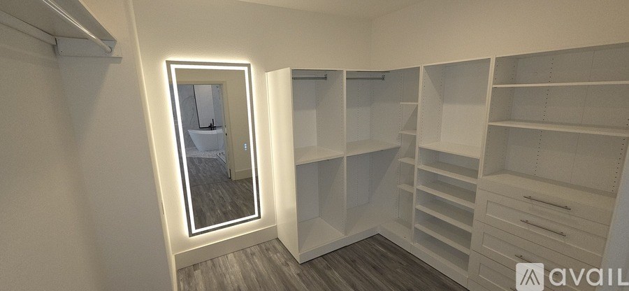 A spacious walk-in closet with white shelving and drawers.