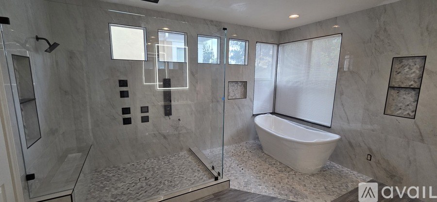 A bathroom with a tub, shower, and a window.