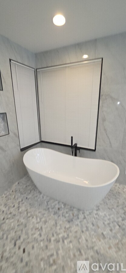 A white bathroom with a white tub and a white shower curtain.