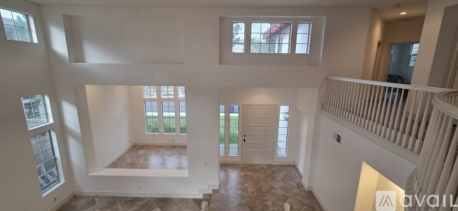 A large, empty house with a balcony and a view of the backyard.