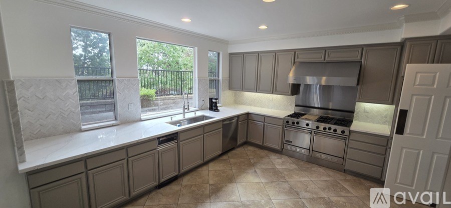 A kitchen with a white countertop and grey cabinets.