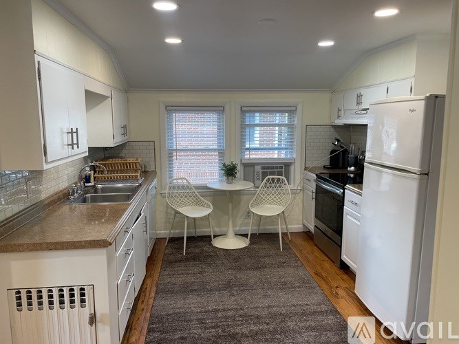 A kitchen with white cabinets and a white fridge.