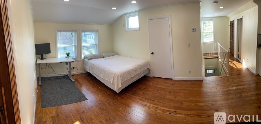 A bedroom with a bed, desk, and chair.