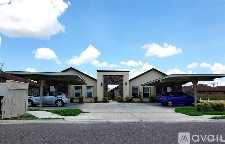 A car dealership with two cars parked in front.