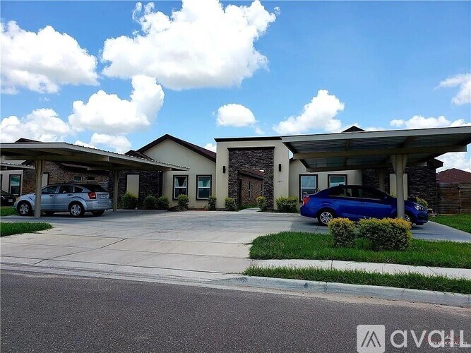 A blue car is parked in front of a house with a covered driveway.
