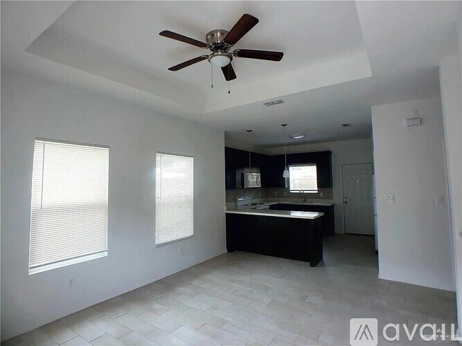 A spacious bathroom with a ceiling fan and a large bathtub.
