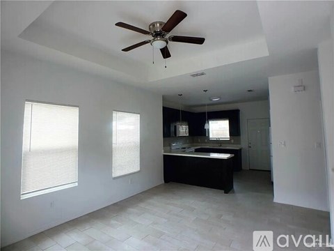 A spacious bathroom with a ceiling fan and a large bathtub.