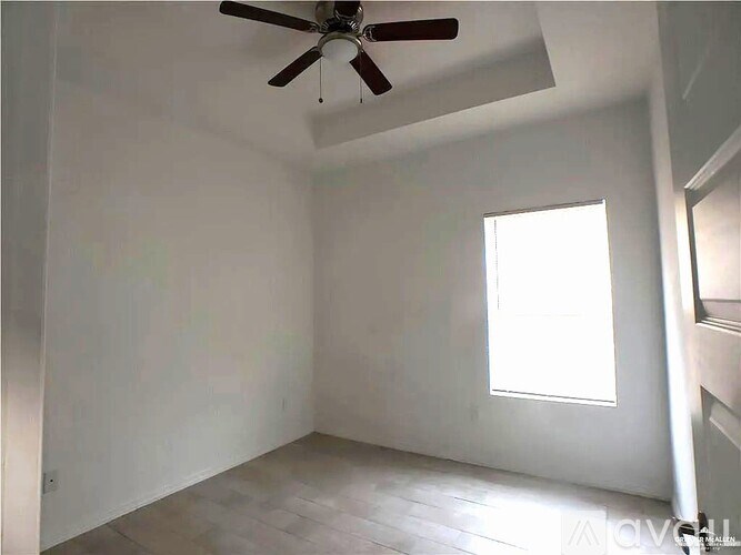 A room with a ceiling fan and a window.