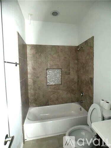 A bathroom with a tub, toilet, and sink.