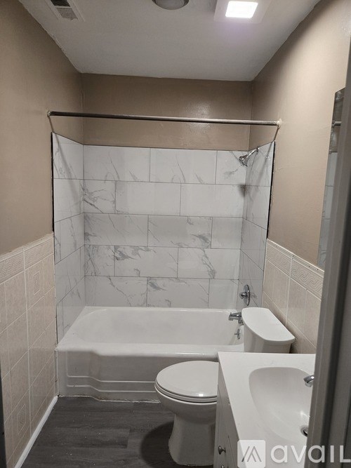 A bathroom with a toilet, sink, and bathtub.