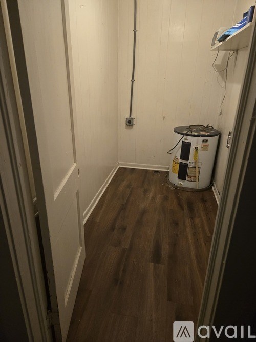 A room with a white wall and a wooden floor.