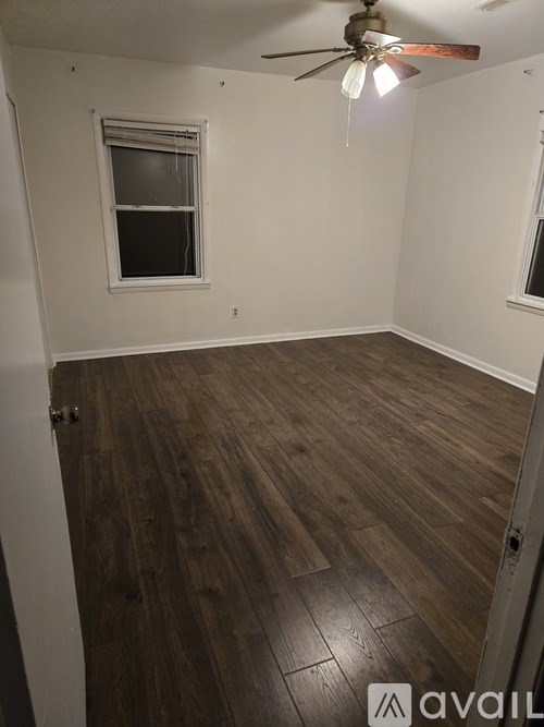 A kitchen with a black fridge and wooden floors.