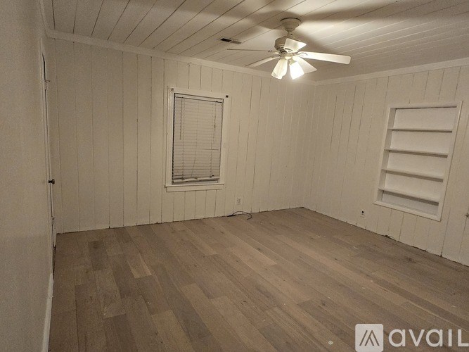 A room with wooden flooring and a ceiling fan.