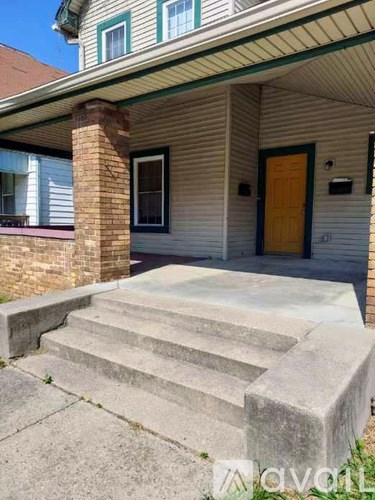 A house with a yellow door and a brick chimney.